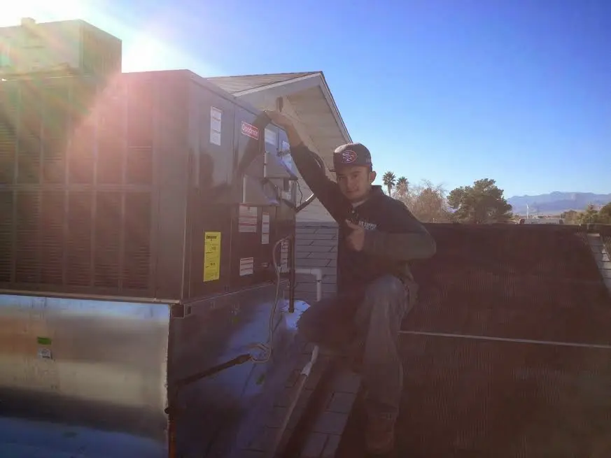 HVAC technician performing Air Duct Cleaning on a rooftop unit in Goldsboro
